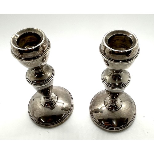 509 - Pair of hallmarked silver candlesticks height 12cm, total overall weight 254g (filled base)