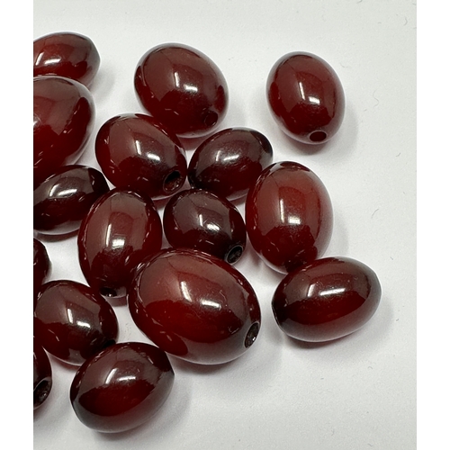 99 - selection of Cherry Amber bakelite beads largest bead measures approx 22mm by 16mm weight 28g