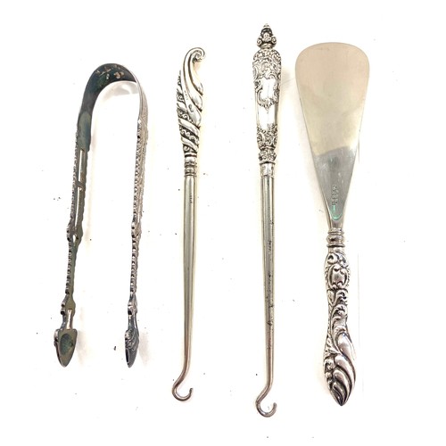 550 - Early pair of sterling silver sugar tongs and button hooks with silver handles and shoe horn