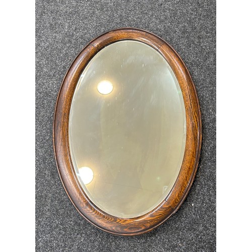 110 - Oak framed oval mirror measures approximately 29 inches by 19 inches