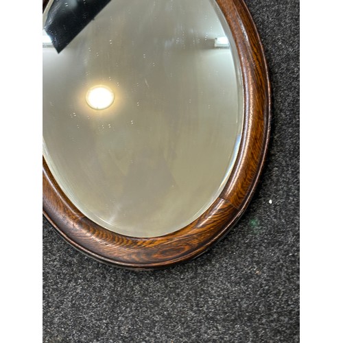 110 - Oak framed oval mirror measures approximately 29 inches by 19 inches