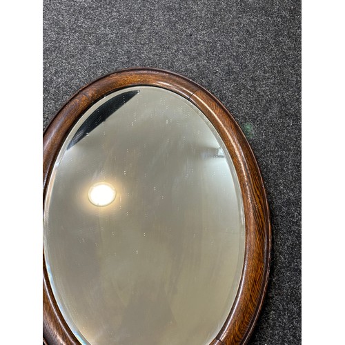 110 - Oak framed oval mirror measures approximately 29 inches by 19 inches