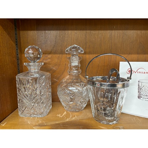 47 - Two cut glass decanters an ice bucket with filter and serving tongs and a set of 6 spirit glasses un... 