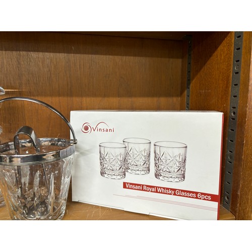 47 - Two cut glass decanters an ice bucket with filter and serving tongs and a set of 6 spirit glasses un... 