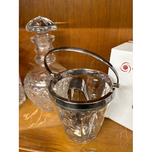 47 - Two cut glass decanters an ice bucket with filter and serving tongs and a set of 6 spirit glasses un... 