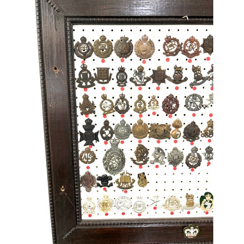 42 - Large selection of assorted Cap badges in a frame