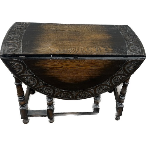 388 - Oak gate leg carved top table measures approximately 29 inches tall x 36 wide and 17 deep