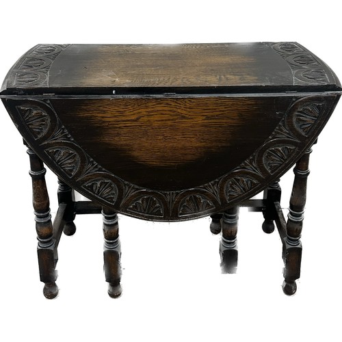 388 - Oak gate leg carved top table measures approximately 29 inches tall x 36 wide and 17 deep