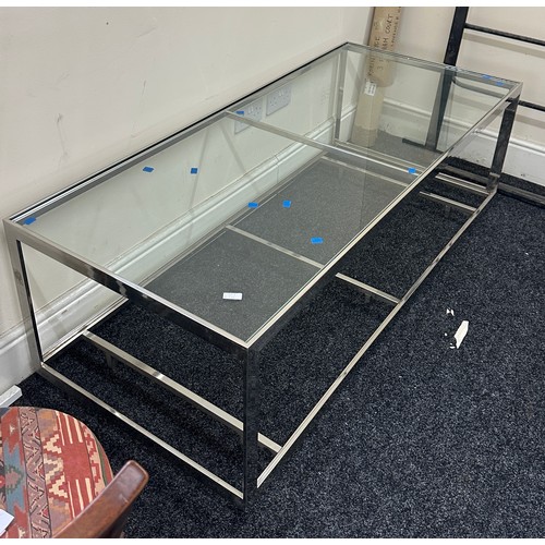 334 - Large chrome and glass low table measures approximately 21 inches tall x 28 wide and 63 long