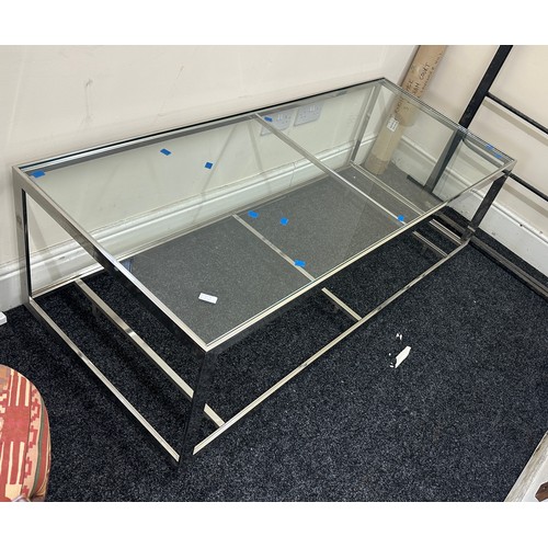 334 - Large chrome and glass low table measures approximately 21 inches tall x 28 wide and 63 long