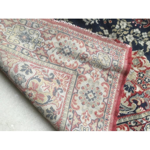 726 - Old traditional blue ground woollen rug with all over red and fawn stylised pattern   285 x 197