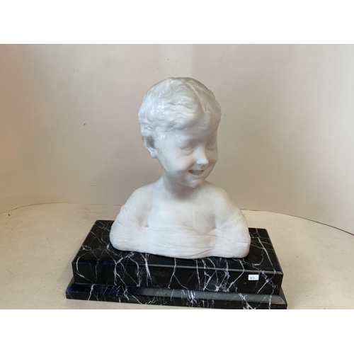 380 - A white marble bust of a smiling boy on a black and white veined marble plinth, 42cmH (condition gen... 