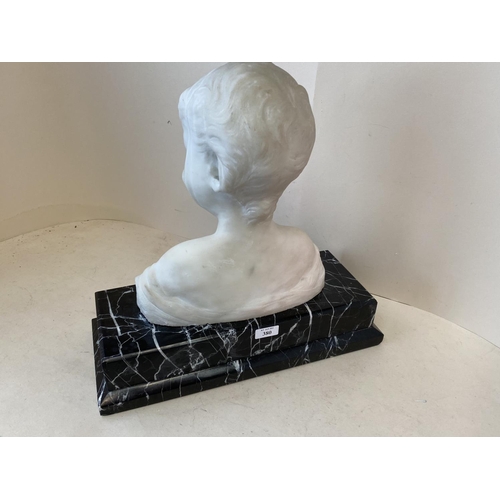 380 - A white marble bust of a smiling boy on a black and white veined marble plinth, 42cmH (condition gen... 