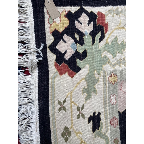 745 - Modern kelim style rug, with black ground and multi pattern, 262 x 140 cm (condition is good)