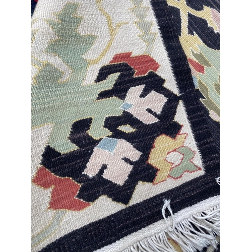 745 - Modern kelim style rug, with black ground and multi pattern, 262 x 140 cm (condition is good)