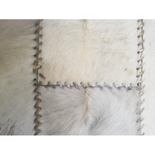 749 - Two contemporary rugs, a grey woolly/sheepskin ; and a contemporary cream and stitched rug