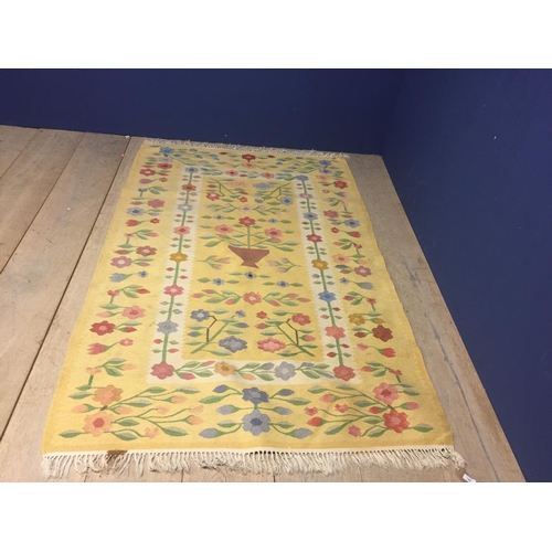 748 - Modern yellow ground rug, with floral patterns  123 cm x 193 cm.  Condition fairly good.   stain on ... 