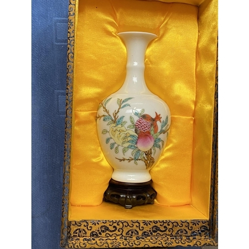 402 - An oriental porcelain vase decorated with a peach, pomegranate and leaf design with plinth