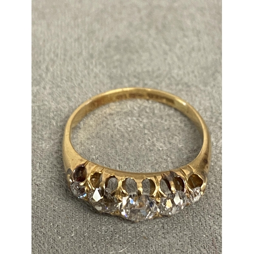 1 - An 18ct gold and diamond five stone ring, set with graduated line of old cut diamonds in a scrolling... 