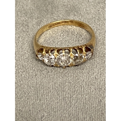 1 - An 18ct gold and diamond five stone ring, set with graduated line of old cut diamonds in a scrolling... 