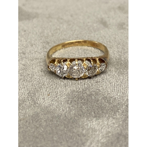 1 - An 18ct gold and diamond five stone ring, set with graduated line of old cut diamonds in a scrolling... 