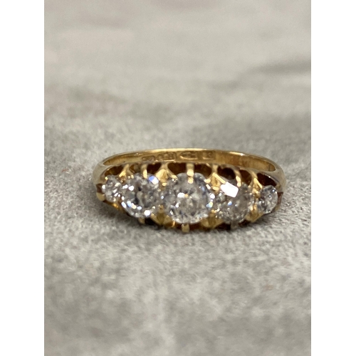 1 - An 18ct gold and diamond five stone ring, set with graduated line of old cut diamonds in a scrolling... 