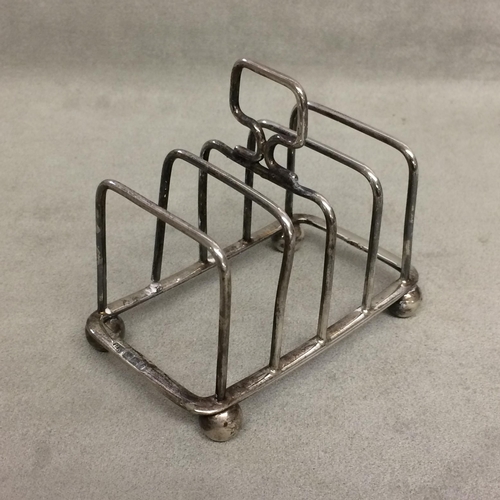 109 - Two sterling silver ashtrays together with a sterling silver toast rack, various dates and makers, 6... 