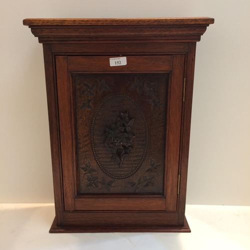 152 - Edwardian hanging wall cabinet with carved front panel, possibly oak, and carved floral rosette to d... 