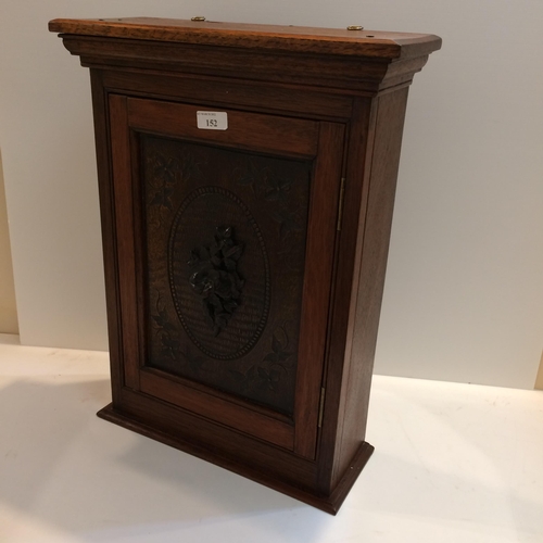 152 - Edwardian hanging wall cabinet with carved front panel, possibly oak, and carved floral rosette to d... 