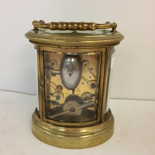 187 - French oval gilt brass four pane carriage clock, striking on a bell with key, losses to glass front ... 