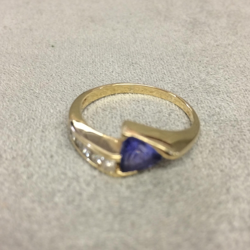 22 - 14k gold Tanzanite and diamond ring, central free cut tanzanite with square channel set diamonds acc... 