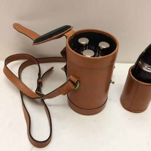 267 - A modern light tan leather hip flask with shoulder strap, the top opening to reveal 3 fitted glass b... 