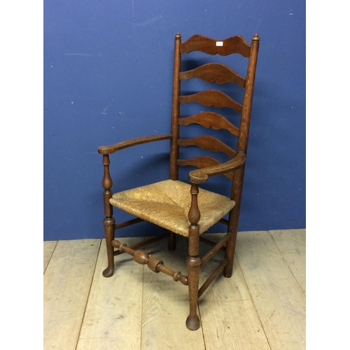 478 - An oak ladder back rush seated arm chair 115cm H x 61.5cm W x 43cm to top of seat x 41cm from back t... 