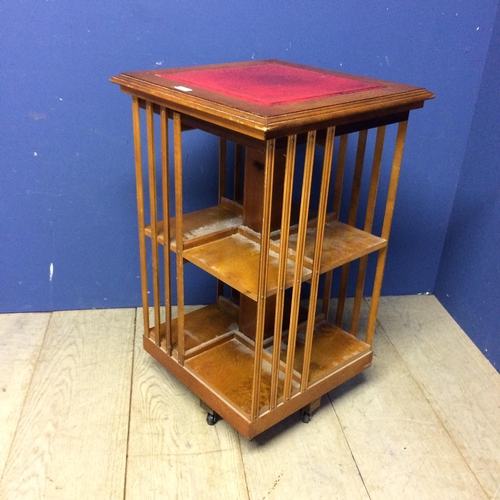 503 - Small revolving light wood pedestal book case with red inset top 78h x 48 x 48cm