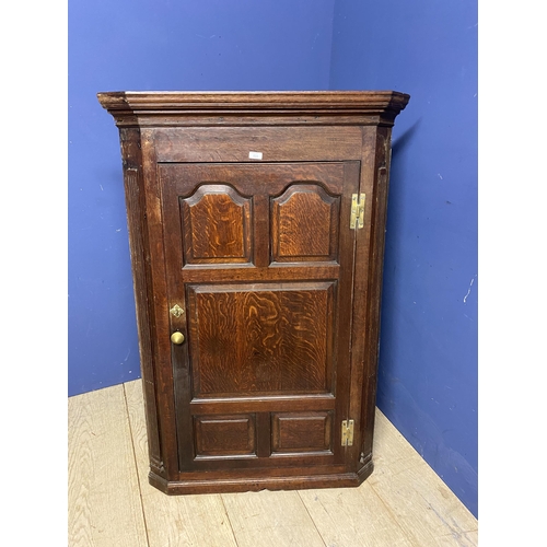 523 - Large oak hanging corner cupboard, with brass plates and handle129h x 86 w x 48 d cm