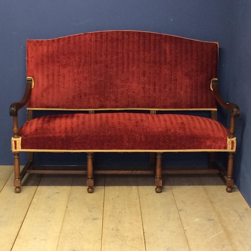 531 - A good heavy oak framed hall settee with carved scrolling arms, and with red upholstered overstuffed... 