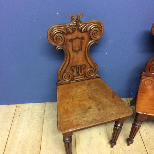 540 - Pair of mahogany shield shaped back hall chairs, with some wear and fading