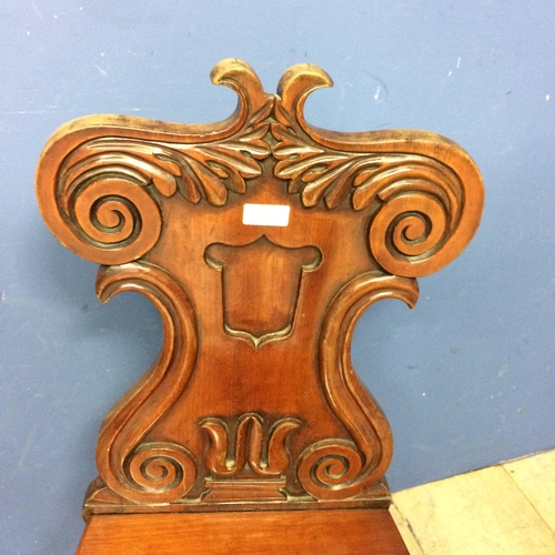 540 - Pair of mahogany shield shaped back hall chairs, with some wear and fading