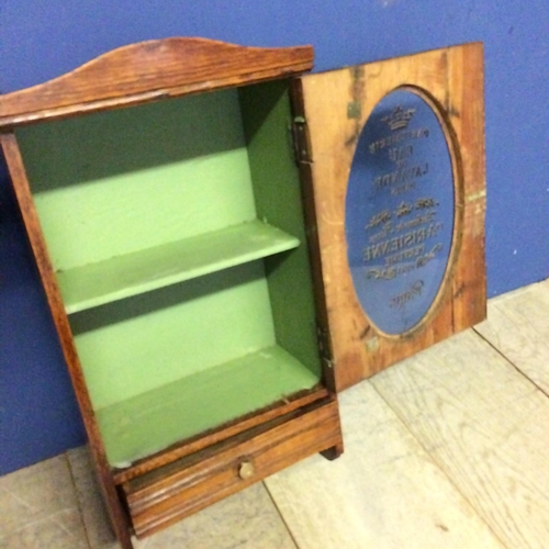 542 - An oak and glazed hanging wall cabinet, with drawer, the glass inscribed 