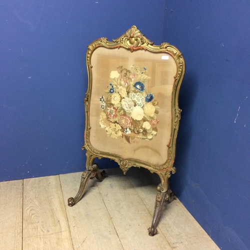 545 - Victorian fire screen, a floral tapestry beneath a glazed front, and with a decorative carved painte... 