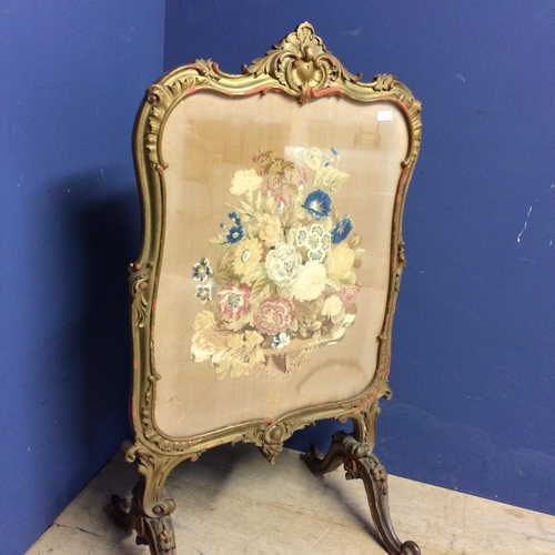 545 - Victorian fire screen, a floral tapestry beneath a glazed front, and with a decorative carved painte... 