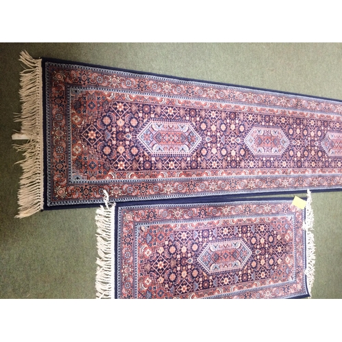 581 - Rugs: Red ground  runner with blue borders and geometric designs, and a similar smaller Runner 269 x... 