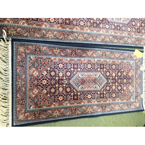 581 - Rugs: Red ground  runner with blue borders and geometric designs, and a similar smaller Runner 269 x... 