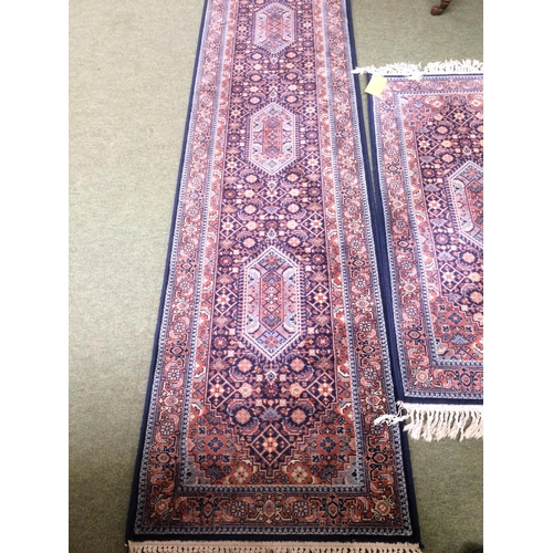 581 - Rugs: Red ground  runner with blue borders and geometric designs, and a similar smaller Runner 269 x... 