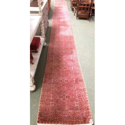 582 - Rugs: A Long red ground runner with all over geometric stylized patterns 72cm x 722cm