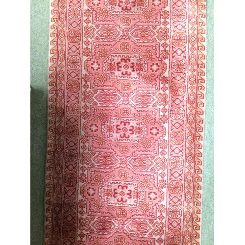 582 - Rugs: A Long red ground runner with all over geometric stylized patterns 72cm x 722cm