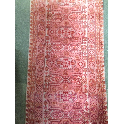 582 - Rugs: A Long red ground runner with all over geometric stylized patterns 72cm x 722cm