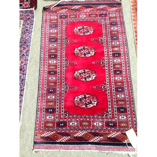 583 - 4 rugs, 3 red ground rugs with all over geometric stylized designs, and a blue and red ground Tree o... 