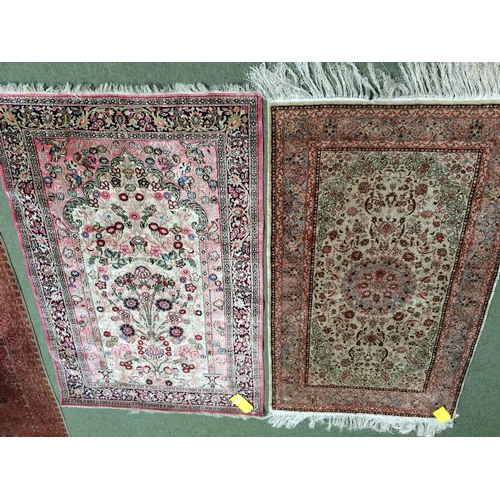 584 - 2 silk rugs, 158 x 102cm; 153 x 93cm, one with square green panel ground and red geometric wide bord... 