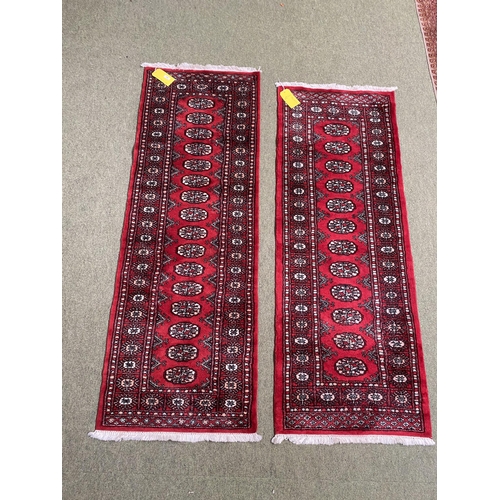 587 - Two Pakistan Bokhara handknotted wool red ground rugs, with central panel of lozenge patterns, and s... 